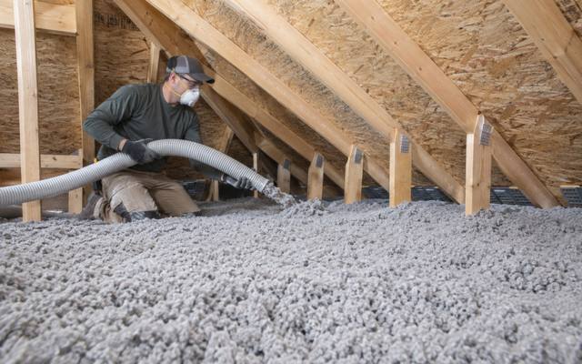 Attic floor covered in a deep, even layer of grey blown cellulose insulation